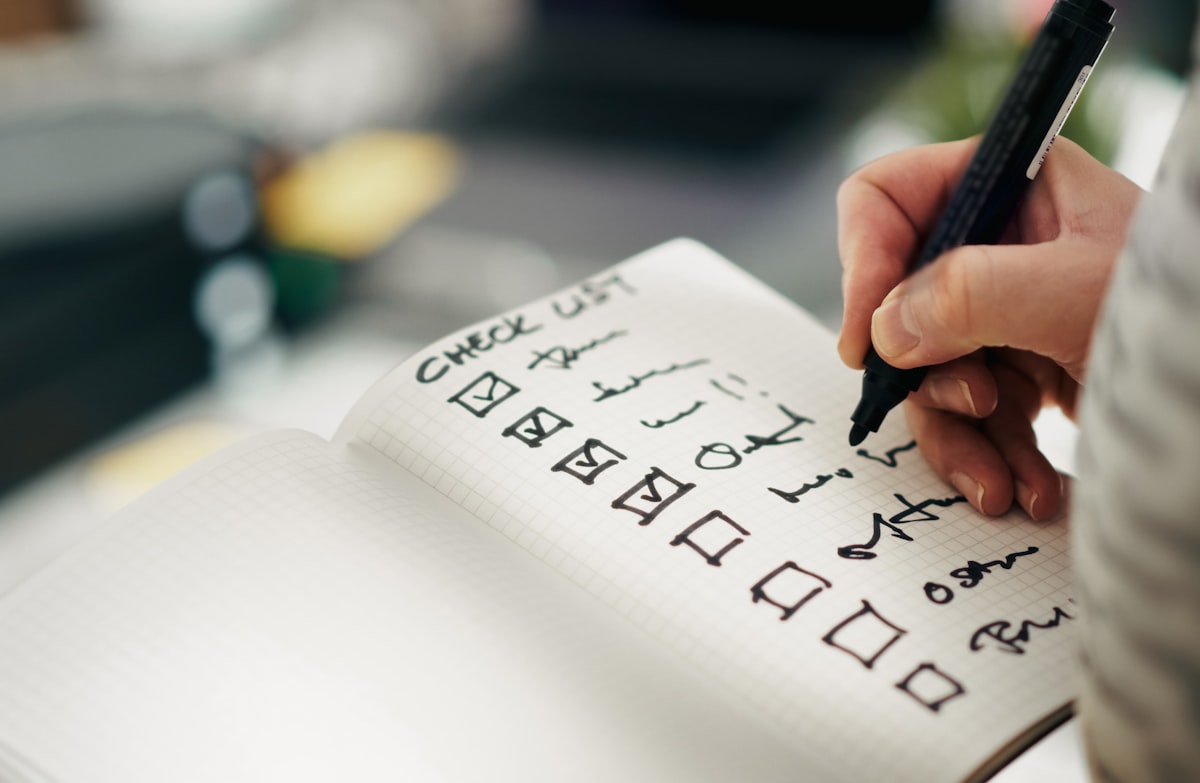 Hand checking items off a written checklist