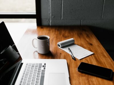 Laptop, coffee, and notes on a work desk