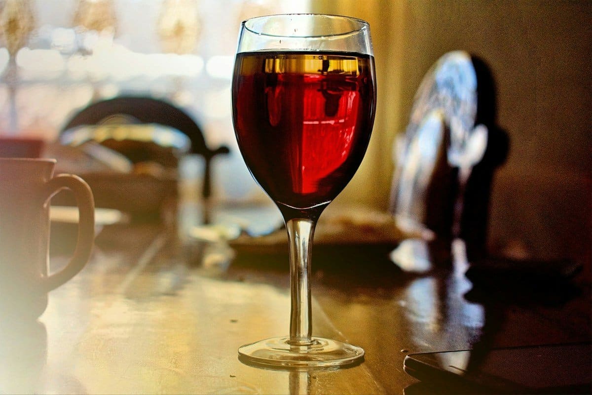 Glass of red wine on a table, one of the drinks that stains teeth