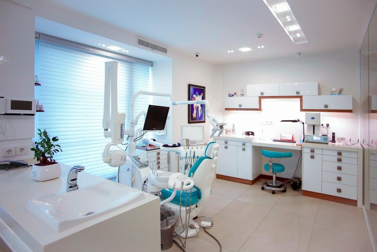 Bright modern dental treatment room with chair, light and monitor