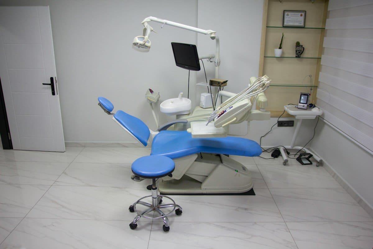 Dental treatment room with a blue chair, light and instruments
