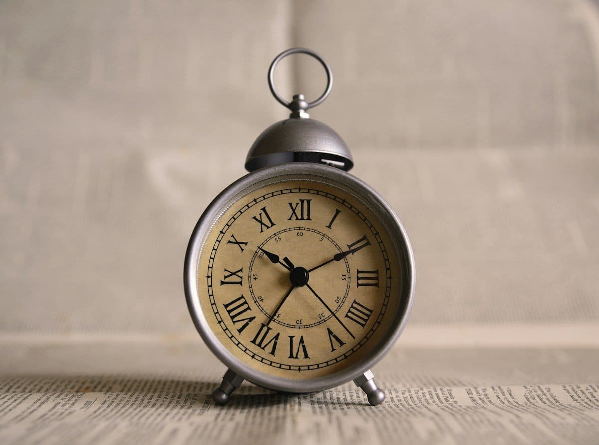 Vintage alarm clock on old newspaper, showing how decay under veneers takes time