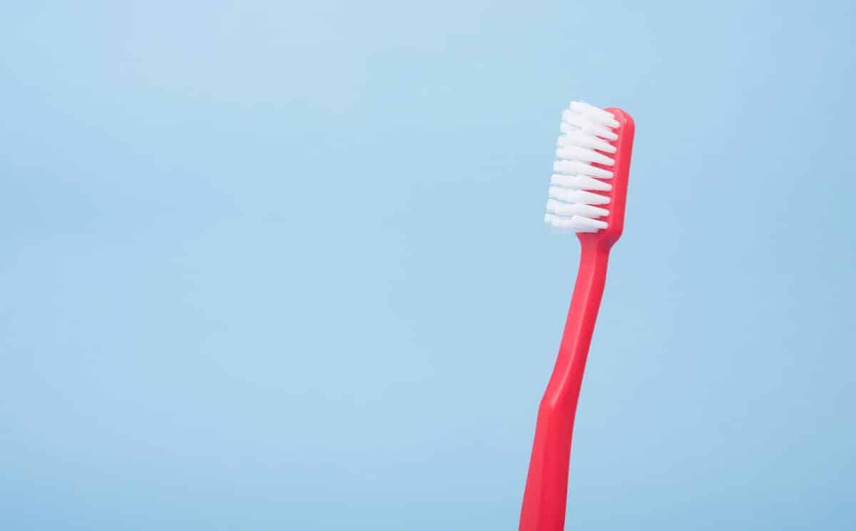 Red toothbrush against a blue background