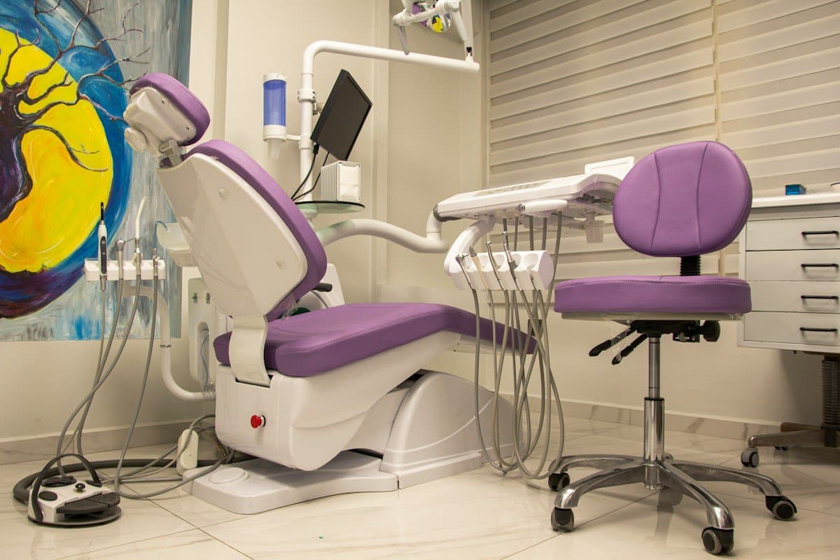 Dental treatment room with a purple chair, instruments and a painting