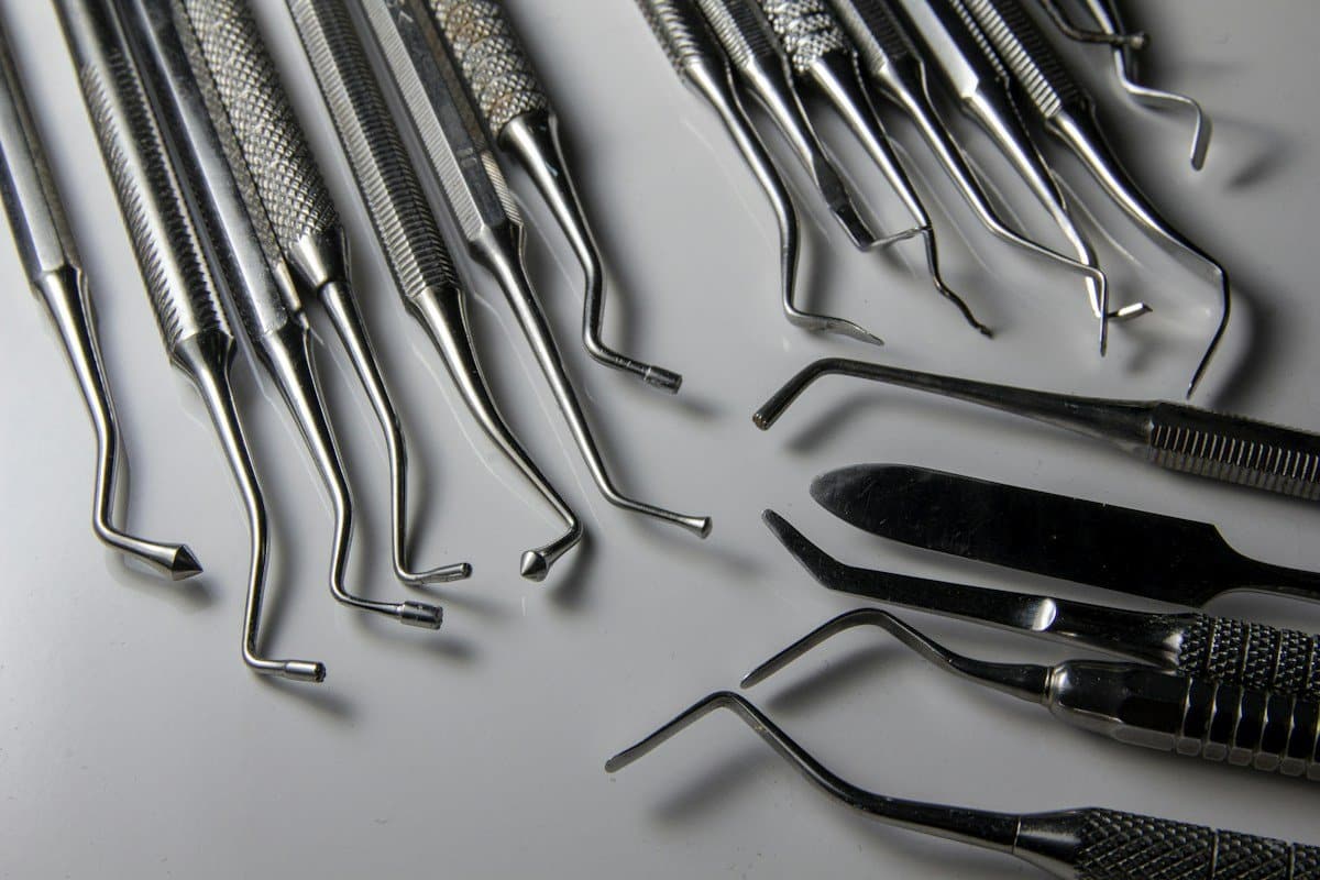 Set of dental instruments laid out on a white surface
