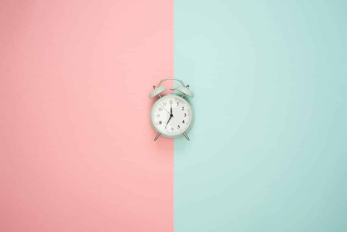 Small alarm clock on a two-tone background, immediate placement saves months