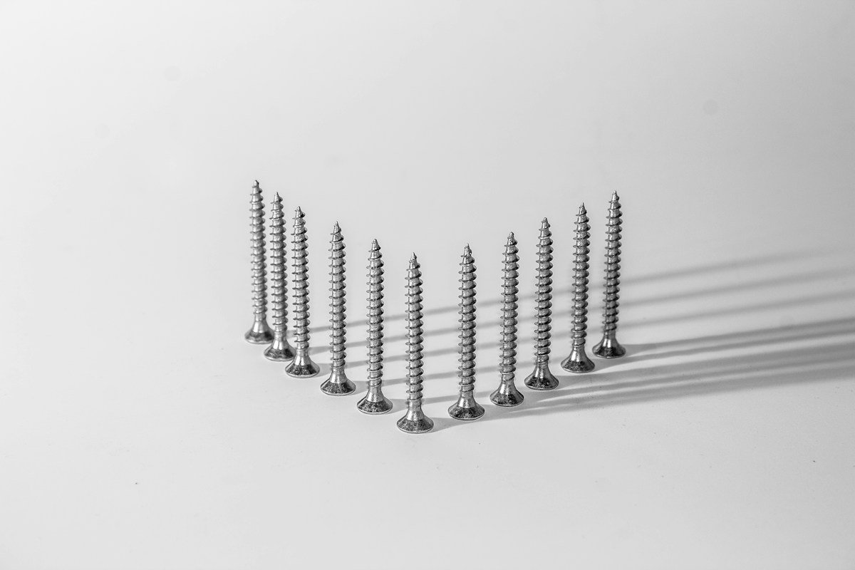 Row of narrow steel screws standing upright, a reminder of mini implant width