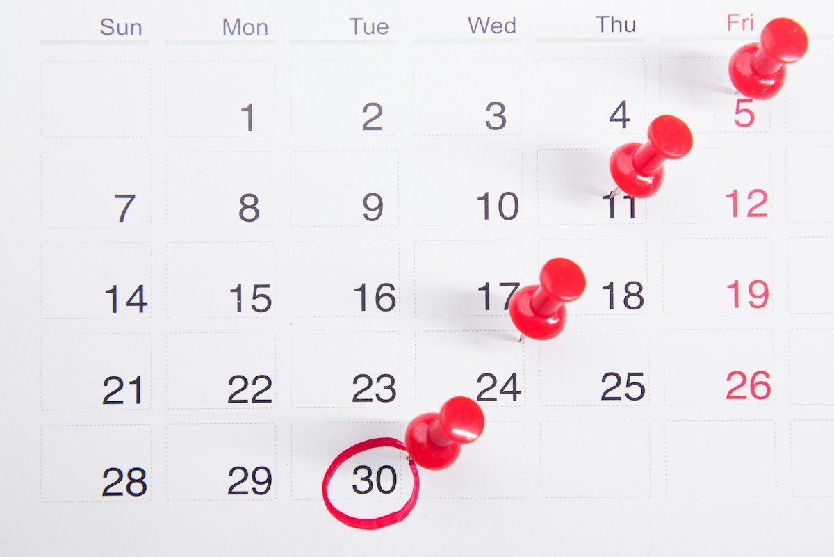 Calendar with red pins marking follow-up dates