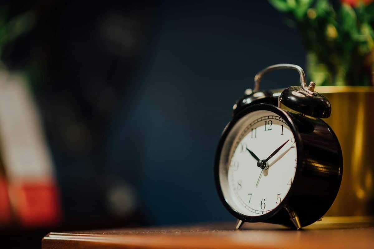 Black alarm clock on a wooden desk