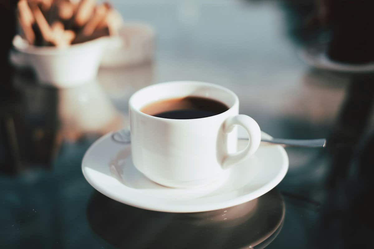 White cup of black coffee on a saucer, a common source of tooth staining