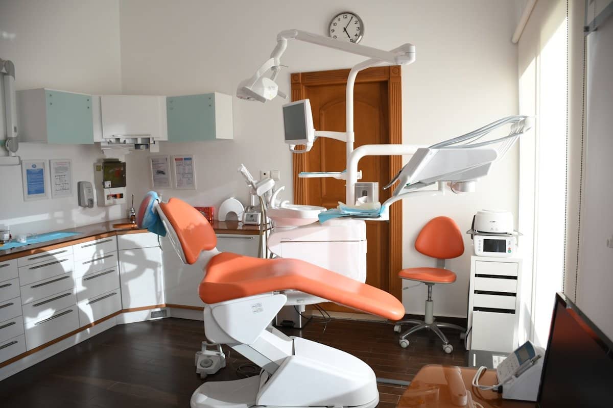 Dental treatment room with a chair, overhead light and monitor